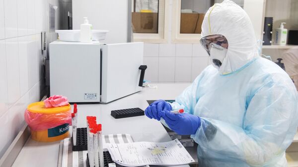 Сотрудник лаборатории проводит тесты на коронавирус Сотрудник лаборатории проводит тесты на коронавирус
