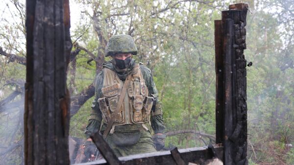 Военнослужащий НМ ДНР осматривает сгоревший дом в поселке Шахты 6-7 в Горловке Военнослужащий НМ ДНР осматривает сгоревший дом в поселке Шахты 6-7 в Горловке