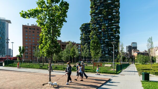 Отдыхающие в парке возле жилого комплекса Bosco Verticale в Милане Отдыхающие в парке возле жилого комплекса Bosco Verticale в Милане