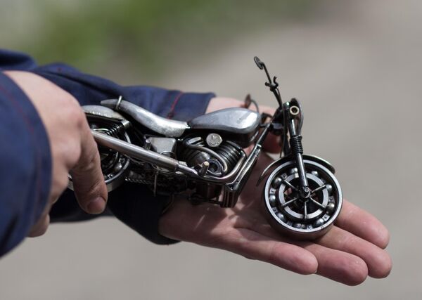 Мастер Станислав Черновасиленко держит миниатюрную копию модели мотоцикла Harley-Davidson Street 750 Мастер Станислав Черновасиленко держит миниатюрную копию модели мотоцикла Harley-Davidson Street 750