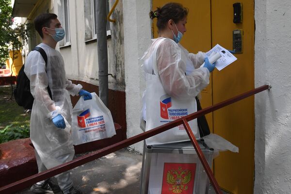 Члены участковой избирательной комиссии во время выездного голосования в Москве по вопросу принятия поправок в Конституцию РФ Члены участковой избирательной комиссии во время выездного голосования в Москве по вопросу принятия поправок в Конституцию РФ