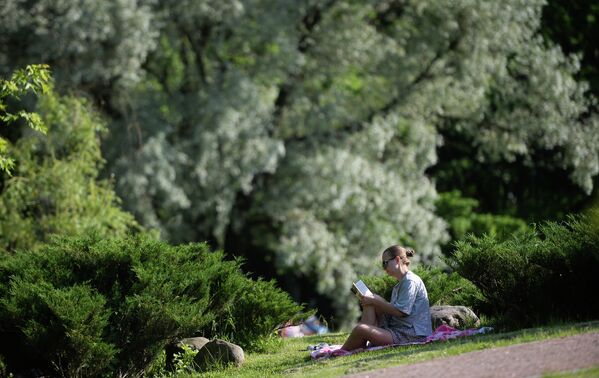 Девушка читает книгу в парке Дубки в Москве Девушка читает книгу в парке Дубки в Москве