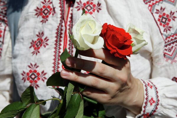 Женщина держит розы во время митинга в поддержку белорусской оппозиции в центре Киева Женщина держит розы во время митинга в поддержку белорусской оппозиции в центре Киева