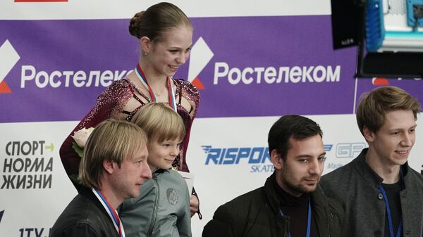 Александра Трусова (в центре на втором плане), Евгений Плющенко с сыном Александром (слева на первом плане) Александра Трусова (в центре на втором плане), Евгений Плющенко с сыном Александром (слева на первом плане)