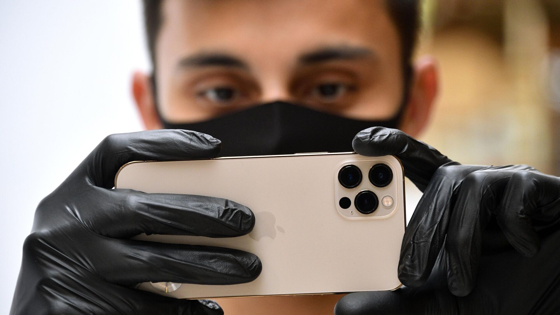 Молодой человек держит в руках новый iPhone 12 Pro Молодой человек держит в руках новый iPhone 12 Pro - РИА Новости, 1920, 05.12.2020