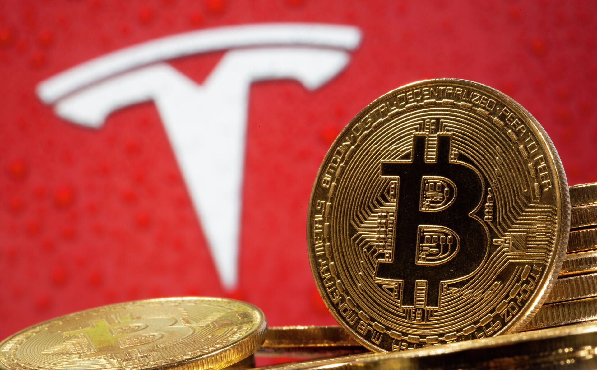 Криптовалюта биткоин на фоне иллюстрации с логотипом Tesla Криптовалюта биткоин на фоне иллюстрации с логотипом Tesla - РИА Новости, 1920, 24.02.2021