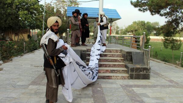 Боевики Талибана* поднимают свой флаг у резиденции губернатора провинции Газни, юго-восток Афганистана