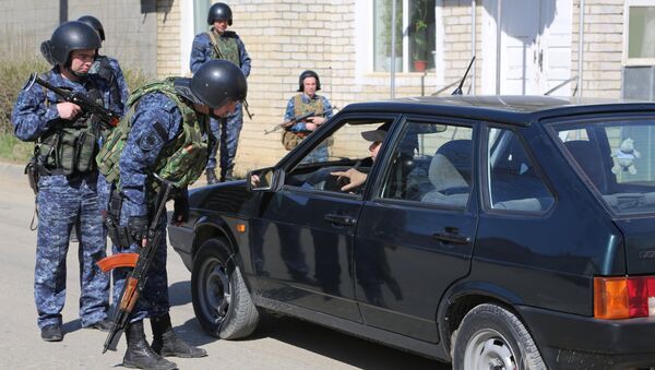 Сотрудники полиции досматривают автомобиль на месте проведения контртеррористической операции. Архивное фото Сотрудники полиции досматривают автомобиль на месте проведения контртеррористической операции. Архивное фото