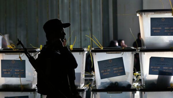 Афганский полицейский стоит на страже у центра подсчета голосов в результате президентских выборов. Архивное фото Афганский полицейский стоит на страже у центра подсчета голосов в результате президентских выборов. Архивное фото