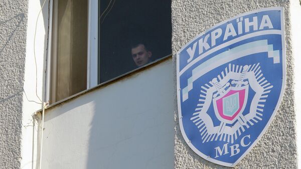 Милиционер смотрит из окна здания областного управления МВД Украины 