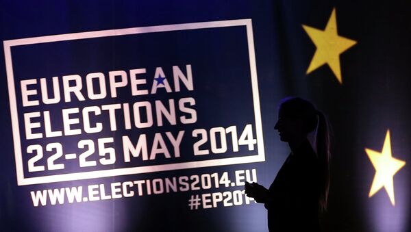 Девушка на фоне баннера с информацией о выборах в Европарламент в Брюсселе. Архивное фото Девушка на фоне баннера с информацией о выборах в Европарламент в Брюсселе. Архивное фото