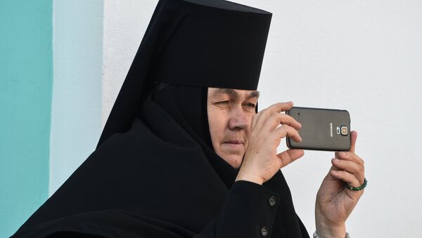 Монахиня фотографирует на мобильный телефон богослужение в Троице-Сергиевой лавре в городе Сергиевом Посаде Монахиня фотографирует на мобильный телефон богослужение в Троице-Сергиевой лавре в городе Сергиевом Посаде