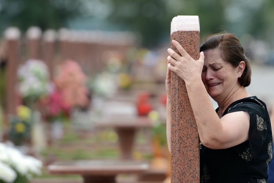Женщина плачет на мемориальном кладбище Город ангелов в Беслане Женщина плачет на мемориальном кладбище Город ангелов в Беслане