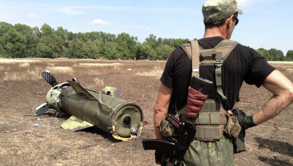 Ополченец Донецкой народной республики (ДНР) у ракеты Точка-У, упавшей в окрестностях города Снежное Ополченец Донецкой народной республики (ДНР) у ракеты Точка-У, упавшей в окрестностях города Снежное