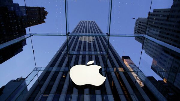 Логотип компании Apple над входом в здание в Нью-Йорке, США