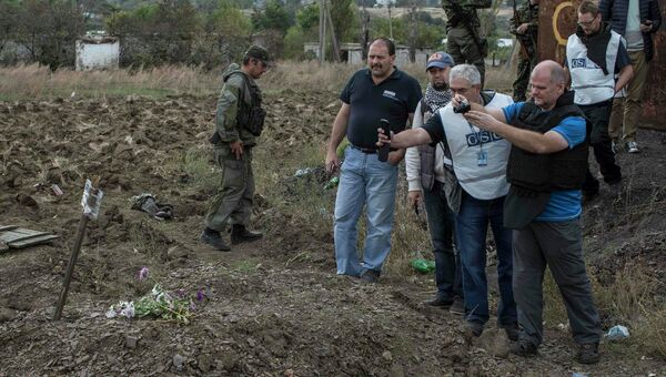 Наблюдатели ОБСЕ на месте захоронения мирных жителей в поселке Нижняя Крынка под Донецком Наблюдатели ОБСЕ на месте захоронения мирных жителей в поселке Нижняя Крынка под Донецком