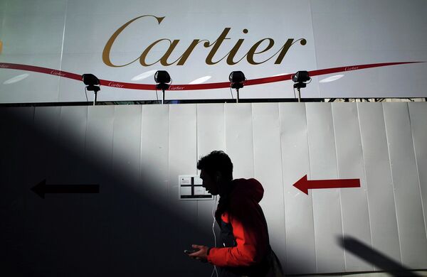 Прохожий на фоне рекламного баннера Cartier. Архивное фото Прохожий на фоне рекламного баннера Cartier. Архивное фото