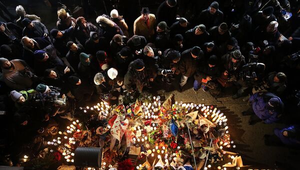 Люди приносят цветы и свечки к месту убийства полицейских в Нью-Йорке. 25 декабря 2014 Люди приносят цветы и свечки к месту убийства полицейских в Нью-Йорке. 25 декабря 2014