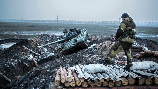 Ополченец стоит у танка украинской армии в Донецкой области. Архивное фото Ополченец стоит у танка украинской армии в Донецкой области. Архивное фото