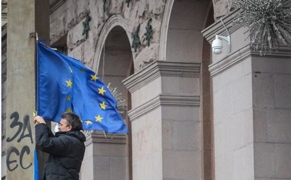 Участник акций за евроинтеграцию Украины закрепляет флаг ЕС Участник акций за евроинтеграцию Украины закрепляет флаг ЕС