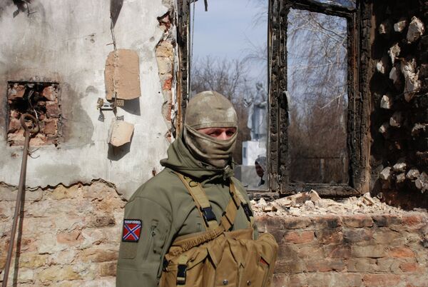 Ополченец ДНР у разрушенного здания в Донецке Ополченец ДНР у разрушенного здания в Донецке