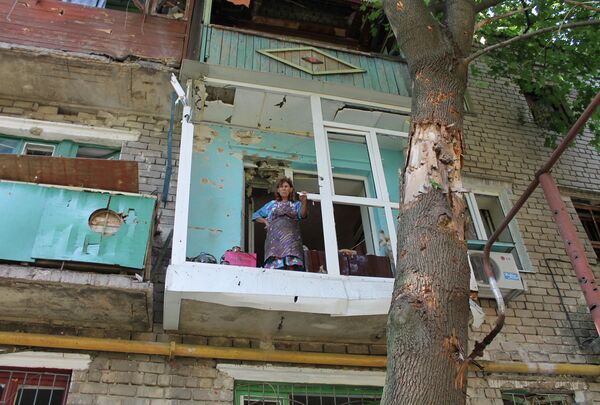 Женщина на балконе квартиры в Горловке после обстрела Женщина на балконе квартиры в Горловке после обстрела
