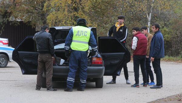 Сотрудник ДПС досматривает машину автовладельца на одной из улиц деревни Тимошкино Сотрудник ДПС досматривает машину автовладельца на одной из улиц деревни Тимошкино