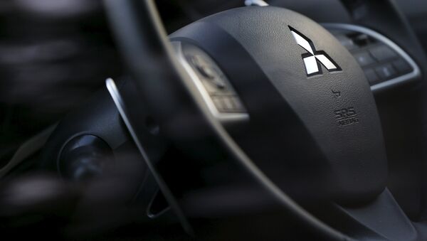 Логотип компании Mitsubishi на рулевом колесе. Архивное фото Логотип компании Mitsubishi на рулевом колесе. Архивное фото