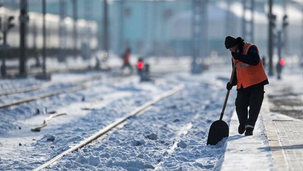Рабочий очищает железнодорожный путь на станции Омск-Пассажирский в Омске Рабочий очищает железнодорожный путь на станции Омск-Пассажирский в Омске