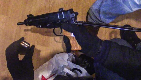 Сотрудник правоохранительных органов демонстрирует огнестрельное оружие и магазин с патронами к нему, изъятое сотрудниками ФСБ РФ у задержанной в Москве диверсионно-террористической группы Сотрудник правоохранительных органов демонстрирует огнестрельное оружие и магазин с патронами к нему, изъятое сотрудниками ФСБ РФ у задержанной в Москве диверсионно-террористической группы