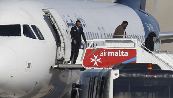 Пассажиры покидают самолет ливийской авиакомпании Afriqiyah Airways в аэропорту Мальты. 23 декабря 2016 Пассажиры покидают самолет ливийской авиакомпании Afriqiyah Airways в аэропорту Мальты. 23 декабря 2016