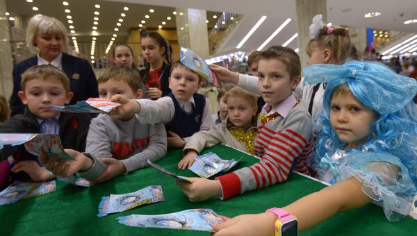 Дети получают подарки после окончания новогоднего представления в Государственном Кремлевском дворце в Москве Дети получают подарки после окончания новогоднего представления в Государственном Кремлевском дворце в Москве