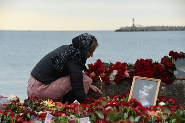 Женщина зажигает свечу в память о жертвах крушения самолета ТУ-154 в Сочи Женщина зажигает свечу в память о жертвах крушения самолета ТУ-154 в Сочи