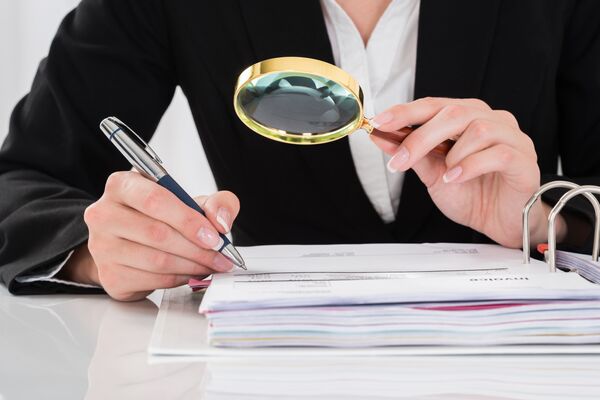 Девушка читает документы с лупой Девушка читает документы с лупой