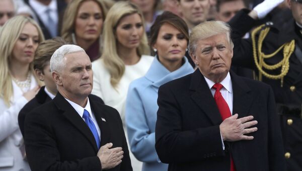 Президент США Дональд Трамп и вице-президент Майк Пенс слушают национальный гимн США во время церемонии инаугурации в Капитолии США в Вашингтоне. 20 января 2017 Президент США Дональд Трамп и вице-президент Майк Пенс слушают национальный гимн США во время церемонии инаугурации в Капитолии США в Вашингтоне. 20 января 2017