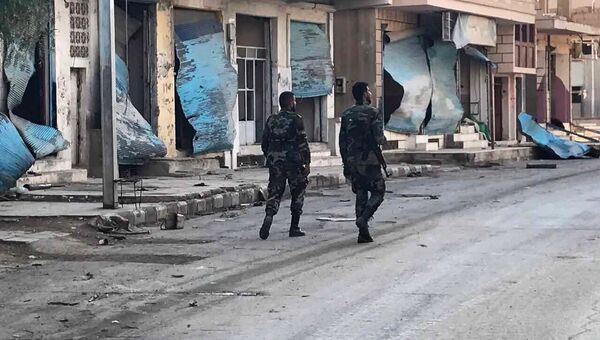 Солдаты у разрушенных в результате боевых действий домов в жилой части города Пальмира в сирийской провинции Хомс Солдаты у разрушенных в результате боевых действий домов в жилой части города Пальмира в сирийской провинции Хомс