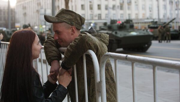 Военнослужащий с девушкой во время прохода военной техники по Тверской улице перед репетицией парада Победы на Красной площади Военнослужащий с девушкой во время прохода военной техники по Тверской улице перед репетицией парада Победы на Красной площади