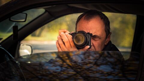 Мужчина фотографирует из окна автомобиля 