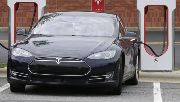 Автомобиль Tesla во время зарядки Автомобиль Tesla во время зарядки