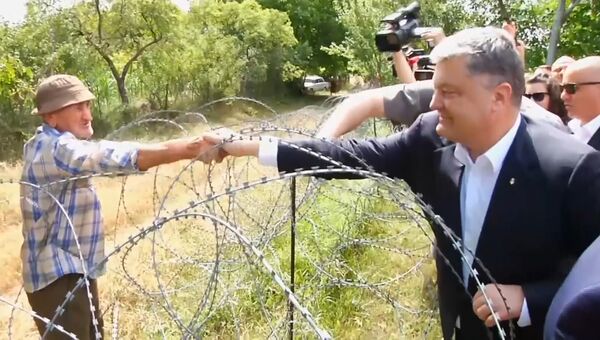 Порошенко в Грузии через границу поздоровался за руку с жителем Южной Осетии Порошенко в Грузии через границу поздоровался за руку с жителем Южной Осетии