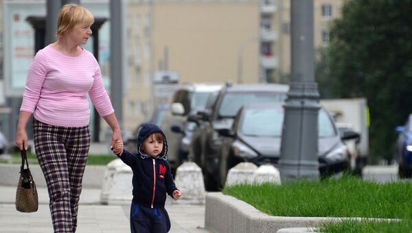 Женщина с ребенком идут по улице Житная в Москве Женщина с ребенком идут по улице Житная в Москве