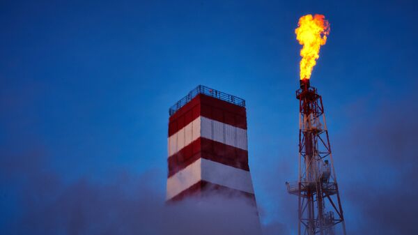 Буровая вышка и газовый факел морской нефтеперерабатывающей платформы. Архивное фото Буровая вышка и газовый факел морской нефтеперерабатывающей платформы. Архивное фото