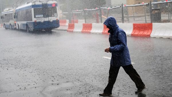 Прохожий во время ливня на одной из улиц Москвы. Архив Прохожий во время ливня на одной из улиц Москвы. Архив