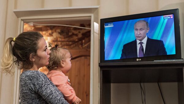Жительница Омска смотрит трансляцию выступления президента РФ Владимира Путина на итоговой сессии международного дискуссионного клуба Валдай. 19 октября 2017 Жительница Омска смотрит трансляцию выступления президента РФ Владимира Путина на итоговой сессии международного дискуссионного клуба Валдай. 19 октября 2017