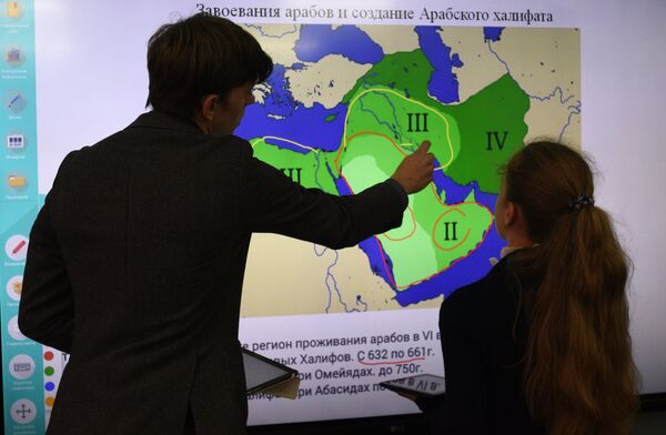 Преподаватель истории и учащийся школы во время урока Преподаватель истории и учащийся школы во время урока