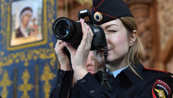 Сотрудник полиции фотографирует во время Божественной литургии в кафедральном соборе Успения Пресвятой Богородицы в Астрахане Сотрудник полиции фотографирует во время Божественной литургии в кафедральном соборе Успения Пресвятой Богородицы в Астрахане