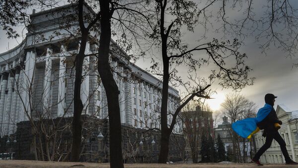 Мужчина с флагом Украины у здания правительства в Киеве, Украина Мужчина с флагом Украины у здания правительства в Киеве, Украина