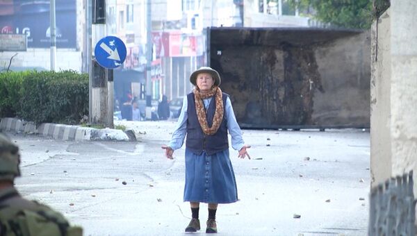 Безоружная пожилая женщина встала между солдатами и протестующими в Вифлееме Безоружная пожилая женщина встала между солдатами и протестующими в Вифлееме