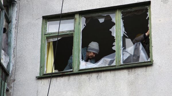 Женщина у окна жилого дома в центре города Ясиноватая, пострадавшего в результате обстрела. 21 декабря 2017 Женщина у окна жилого дома в центре города Ясиноватая, пострадавшего в результате обстрела. 21 декабря 2017