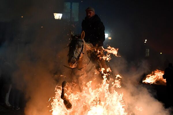 Всадник прыгает через костер во время огненного фестиваля Las Luminarias в Испании Всадник прыгает через костер во время огненного фестиваля Las Luminarias в Испании